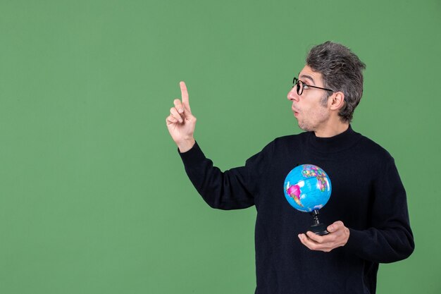 portrait of genius man holding earth globe studio shot green background nature planet teacher sea school space