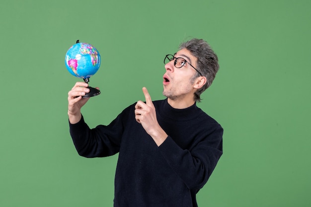 portrait of genius man holding earth globe studio shot green background sea nature space teacher planet air school