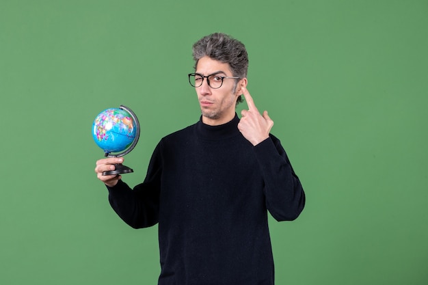 portrait of genius man holding earth globe studio shot green background space teacher nature air sea