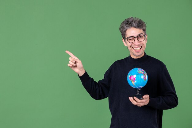 portrait of genius man holding earth globe studio shot green background teacher sea nature space air school