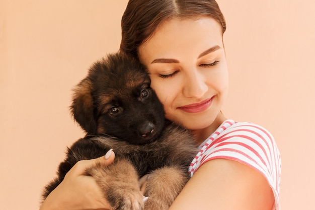 Portrait of German shepherd puppy posing on woman's hands