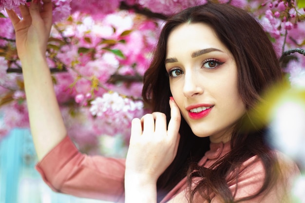 Portrait of a girl against the backdrop of a garden with sakura