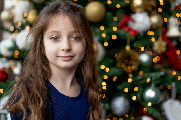 クリスマスツリーの向こうの女の子の肖像画