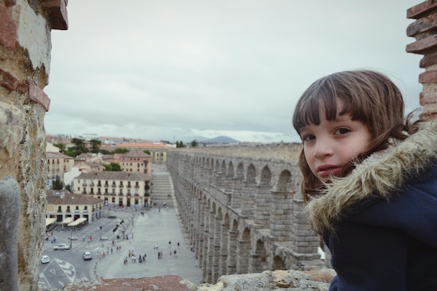 Foto ritratto di una ragazza contro vecchie rovine in città