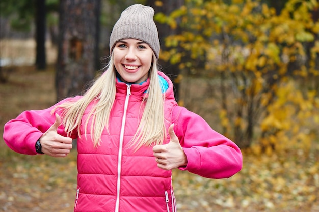 Portrait of a girl athletes in the jacket and cap in the woods. A healthy lifestyle