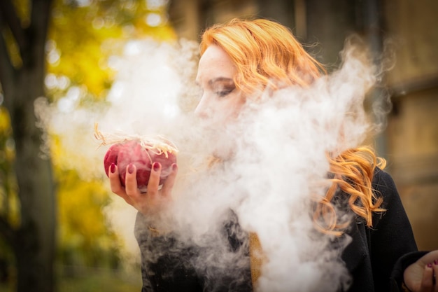 Foto ritratto di una ragazza in autunno la ragazza tiene una zucca rossa nelle mani halloween