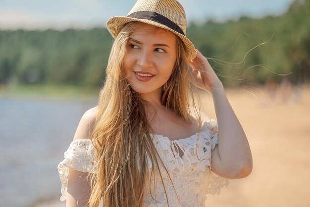 Foto ritratto di una ragazza con un cappello da spiaggia in un giorno d'estate all'aperto