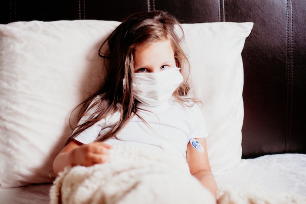 portrait girl in bed with a thermometer