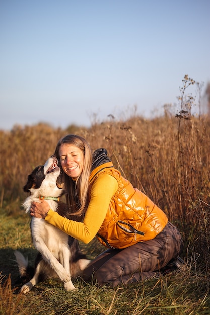 Portrait of a girl and border collie in the field