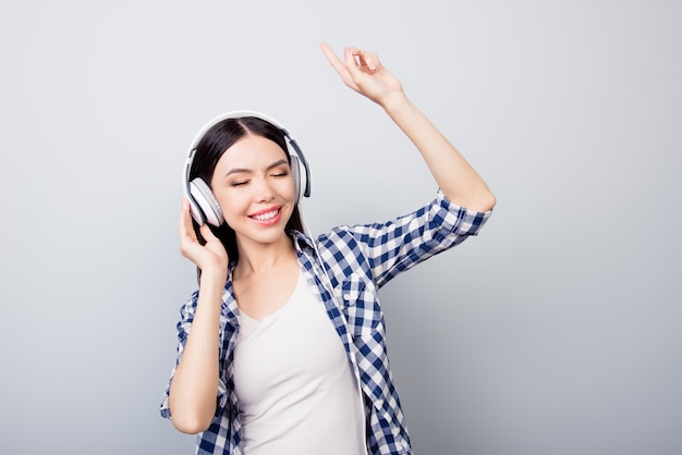 Portrait of girl in casual clothes is listening music dancing