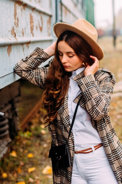 Portrait of a girl in a checkered coat and hat on a walk