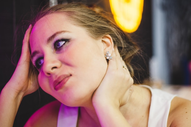 Portrait of a girl in a city cafe, neon lighting and youth style