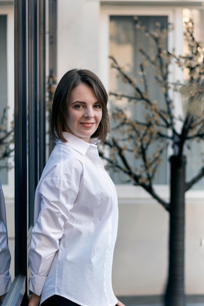 Portrait of girl in classic white shirt Beautiful young woman in the style of casual Successful woman