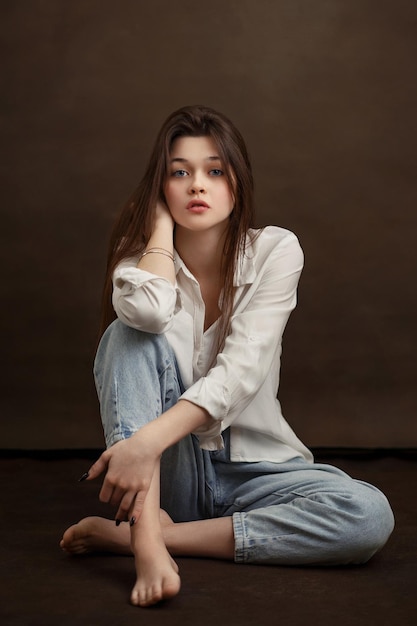 Portrait of a girl closeup a girl on a brown background a beautiful look