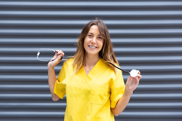 Portrait of girl doctor in uniform displaying stethoscope