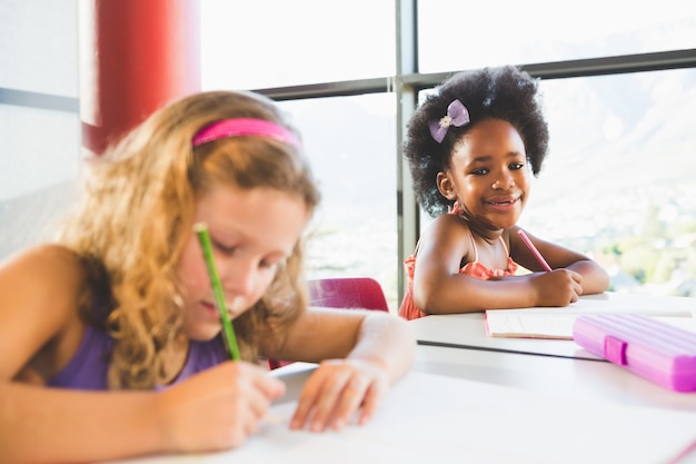 Portrait of girl doing homework in classroom