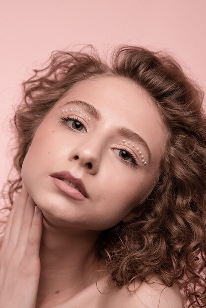 портрет девушки скрестив руки изолирован на розовом