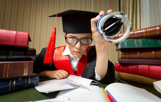 Ritratto di ragazza con cappello di laurea che mette timbro sul documento