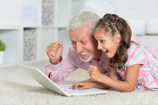 Portrait of girl and grandfather with a tablet