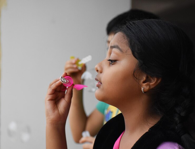 Photo portrait of girl holding bubble stick
