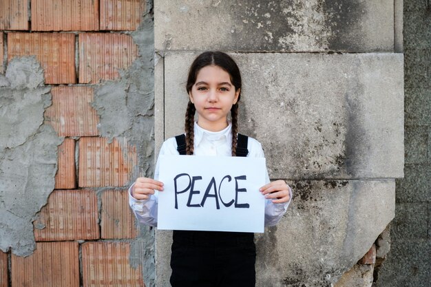 Foto ritratto di una ragazza che tiene un poster contro la parete