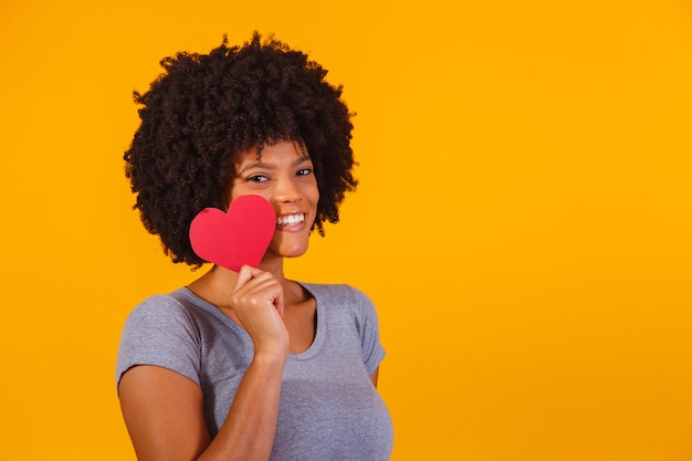 Portrait Of Girl Isolated Holding a Paper Heart on yellow