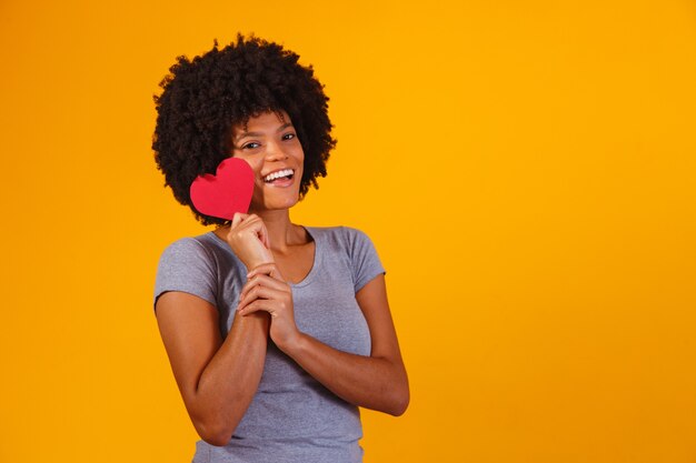 Portrait Of Girl Isolated Holding a Paper Heart on yellow