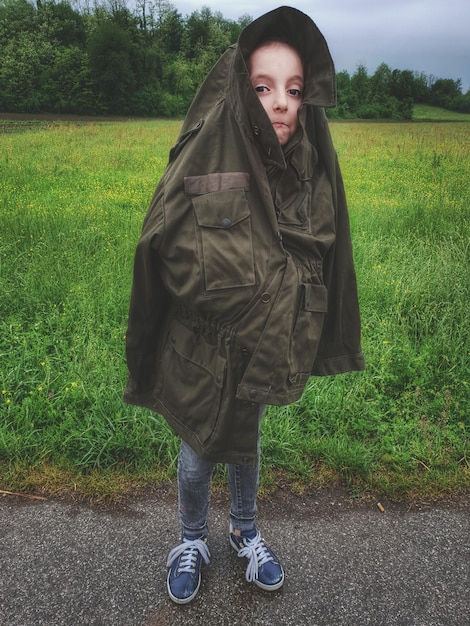 Photo portrait of girl in jacket standing on road against field