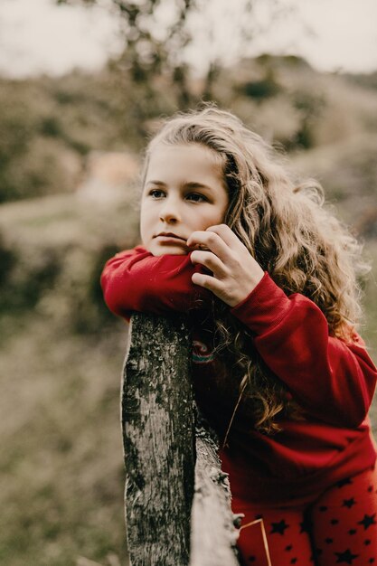 Portrait of girl leaning on wooden fence