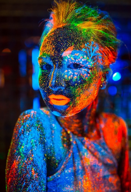 Ritratto di una ragazza dipinta in polvere fluorescente.