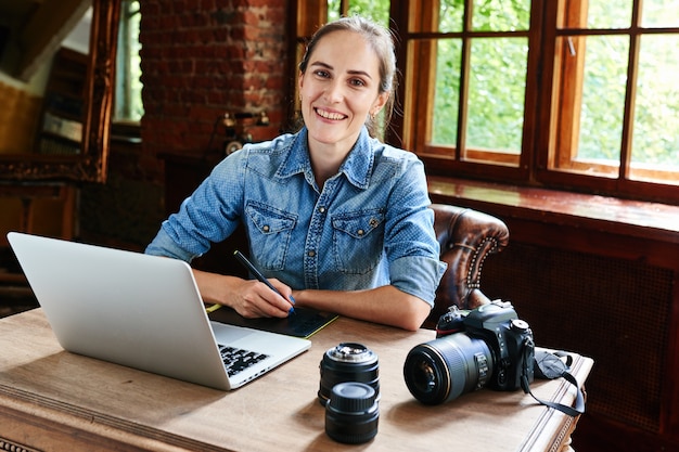 Portrait of a girl photographer working with a computer