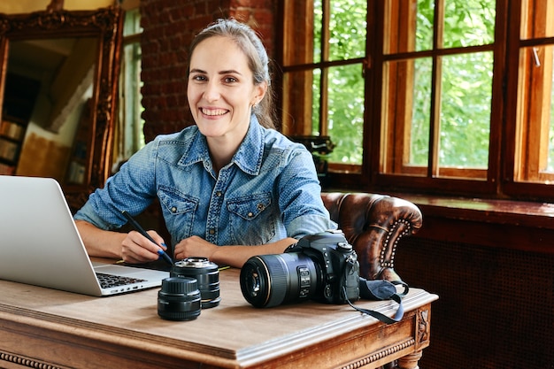 Ritratto di una fotografa ragazza che lavora con un computer