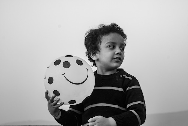 Photo portrait of girl playing with balloons against wall