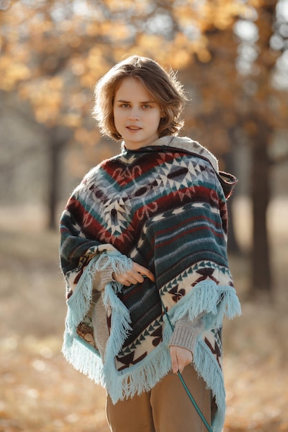 Portrait of a girl in a poncho closeup photo in nature