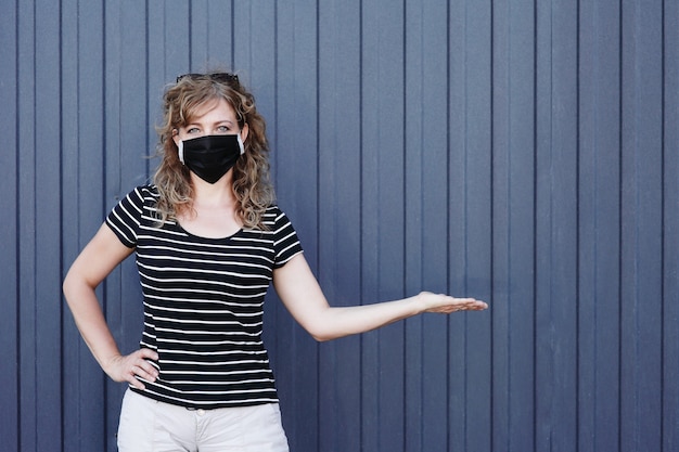 Portrait of a girl in a protective mask against a blue wall