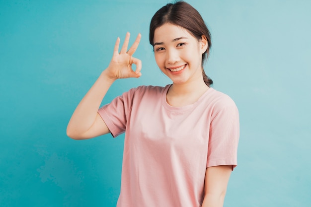 Portrait of girl raising hands of acceptance on blue