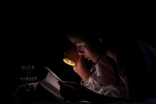 portrait of girl reading with flashlight