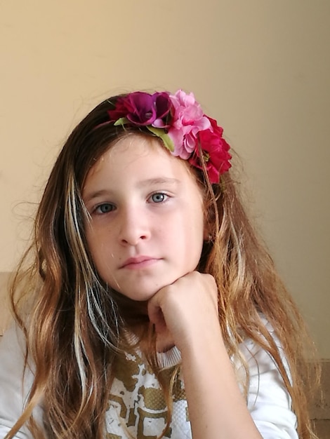 Photo portrait of girl sitting against wall