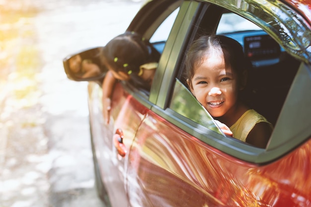 Portrait of girl sitting in car seen through window