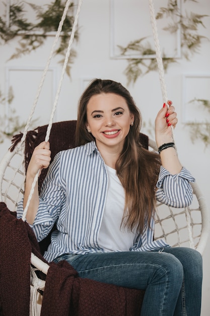 Photo portrait of a girl sitting in a hanging chair