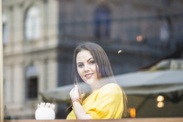 portrait of a girl sitting outside the window in a cafe