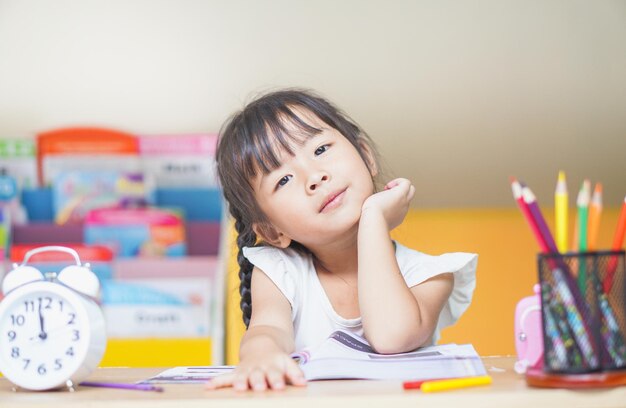 portrait of girl sitting sitting by table at home