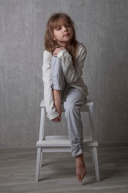 portrait of girl sitting on step ladder