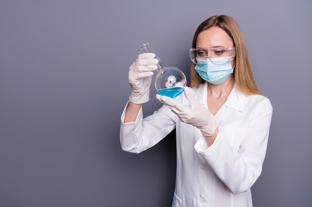 Portrait of girl skilled doc biologist holding in hands test tube analyzing