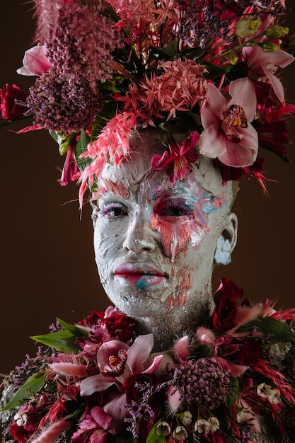 Портрет девушки, намазанной глиной, в зацементированном платье. На голове девушки портрет живых цветов.