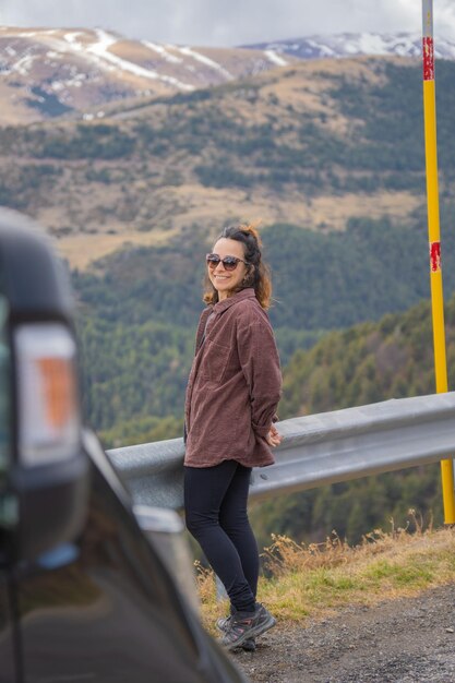 Portrait of girl smiling next to roadside billboard wearing sunglasses