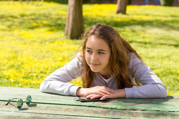 Foto ritratto di una ragazza che sorride mentre è seduta sul tavolo