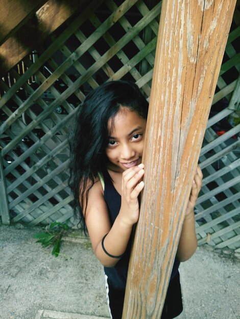 Photo portrait of girl smiling while standing by pole