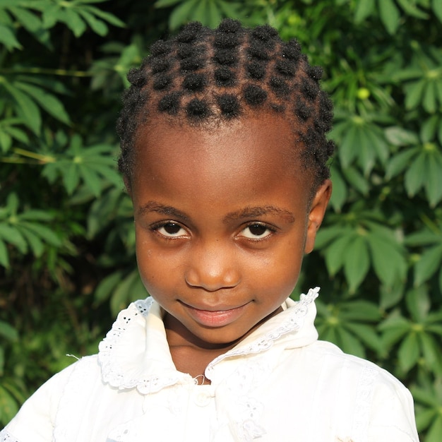 Portrait of girl standing against plants