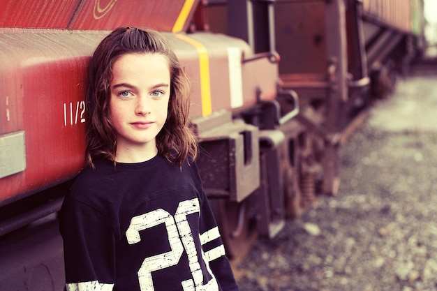 portrait of girl standing against train